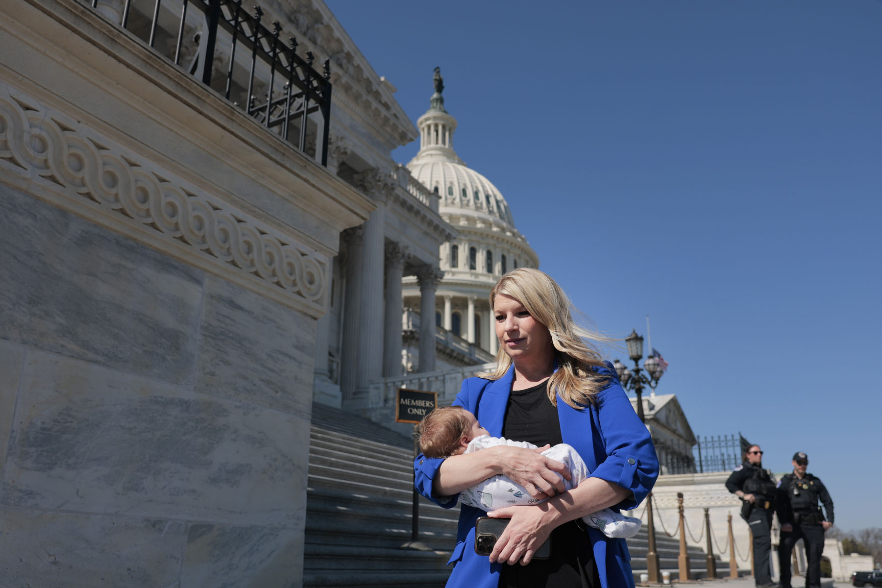 Rep. Brittany Pettersen holds her one-month old baby as she departs during a series of votes at the Capitol.