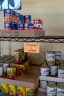 Sparse shelves display canned goods in a community food bank.