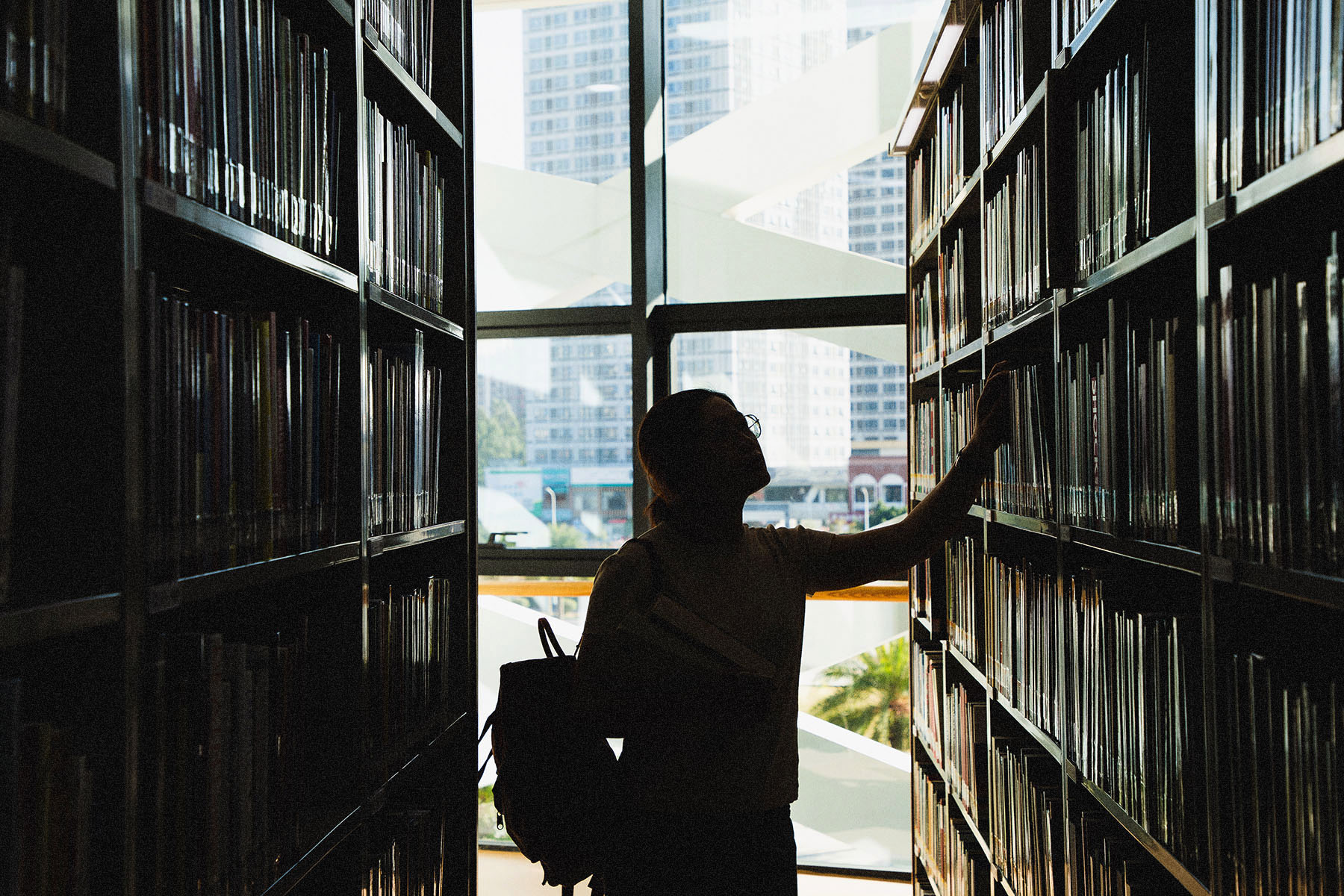 A student looks at books in a library.