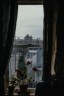 A street view from Ruano’s window, framed by houseplants and curtains.