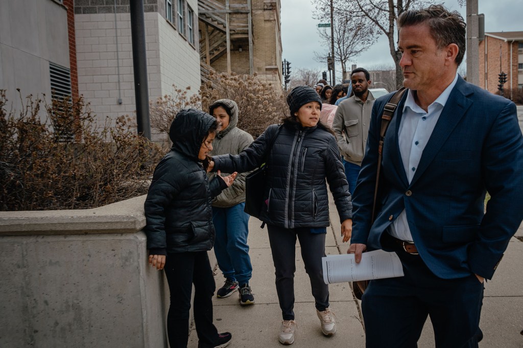 Ruano and her attorney walk toward the ICE building with her daughters.