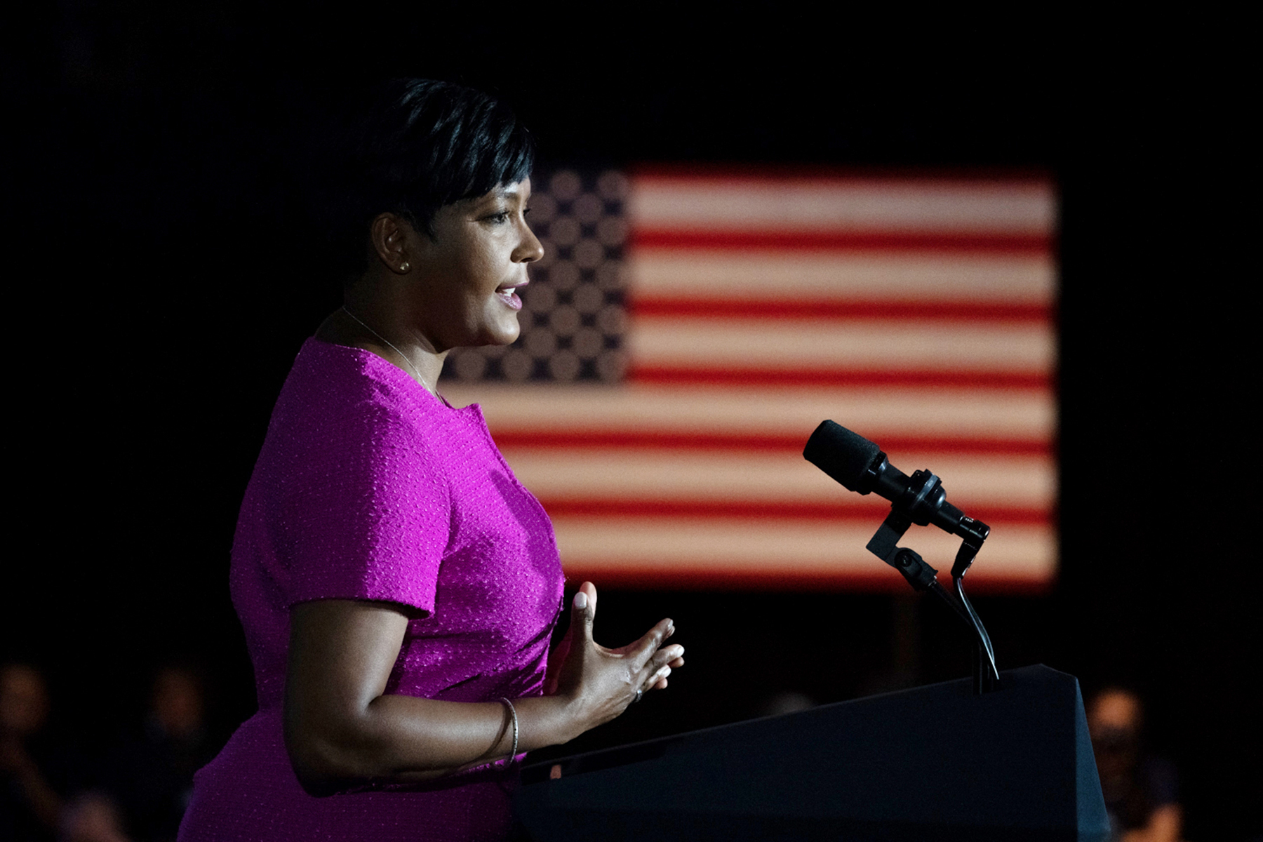 Keisha Lance Bottoms stands at a podium in front of an American flag.