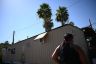 A woman walks toward an air conditioning unit near a trailer.