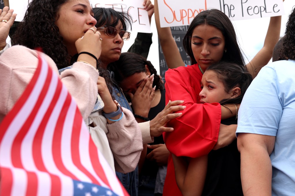 A family cries, holding each other.