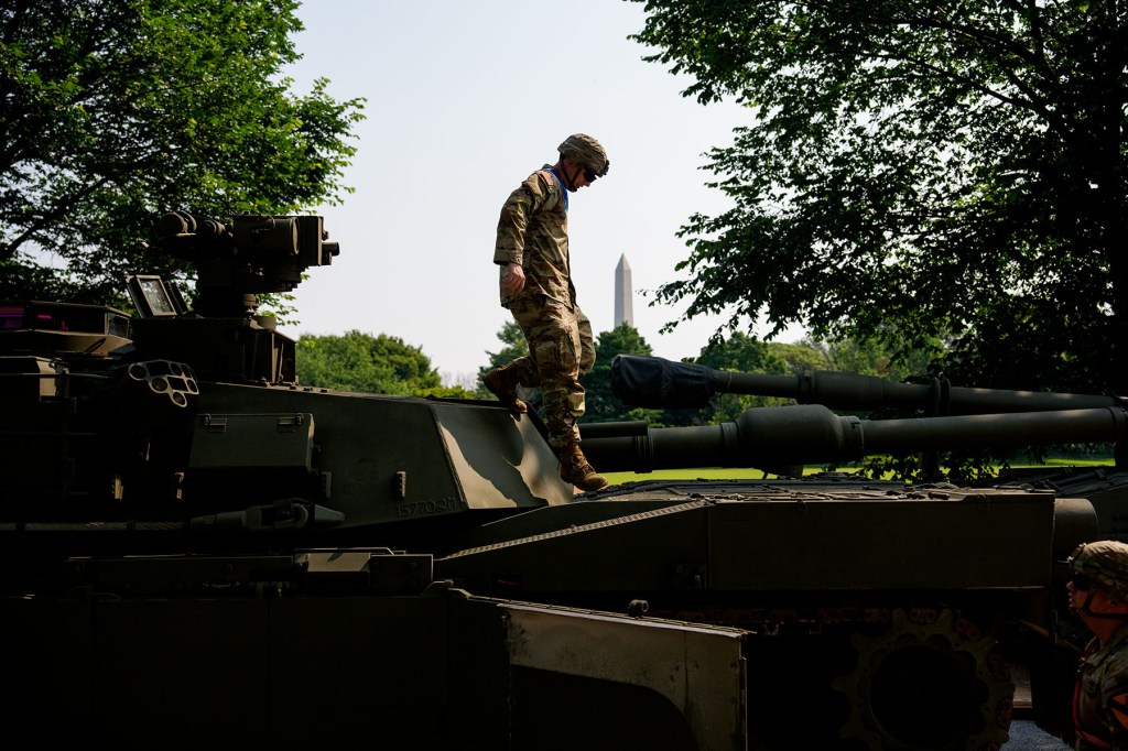 The Washington Monument is visible as U.S. Army soldiers work on an assortment of M1 Alpha a3 Abrams tanks, stryker armored vehicles, and M2 Bradley fighting vehicles at West Potomac Park.