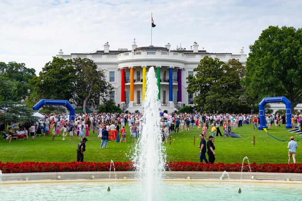 The White House front lawn is full of people and rainbow colored decorations.