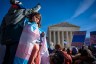 A child looks out at the crowd during a protest in support of care for transgender youth outside the Supreme Court during the United States v. Skrmetti arguments.