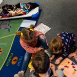 A child sleeps as some of his classmates play during nap time at a daycare center in Nampa, Idaho.