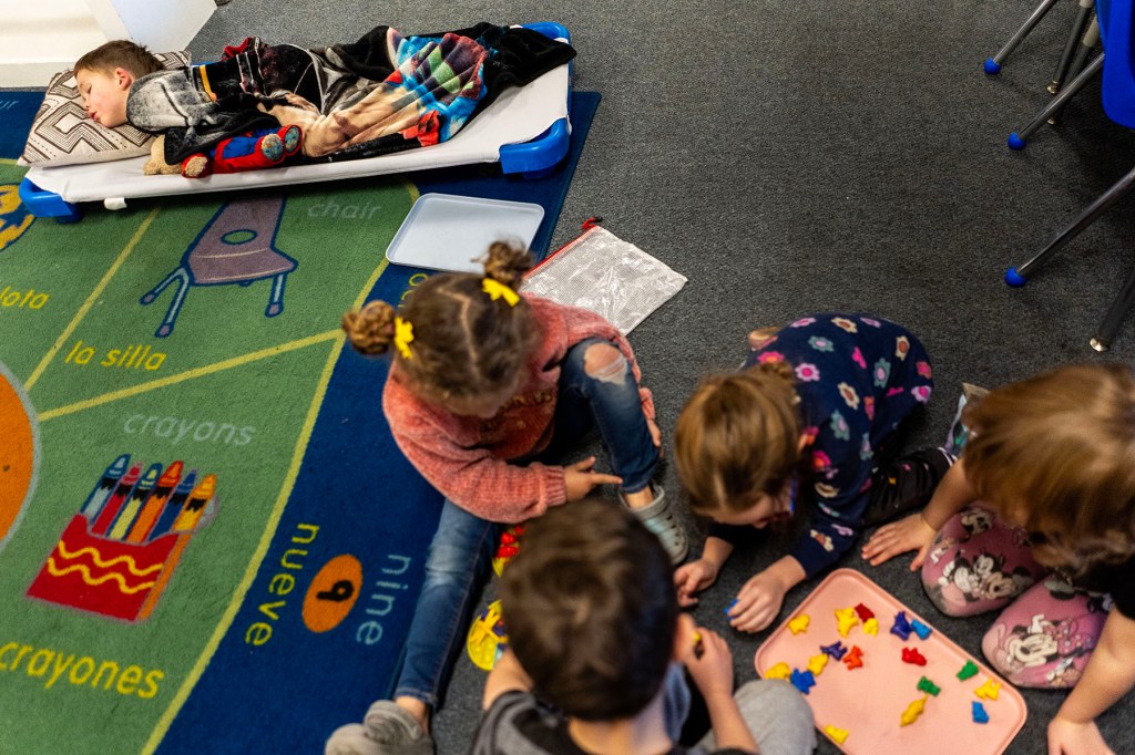 A child sleeps as some of his classmates play during nap time at a daycare center in Nampa, Idaho.