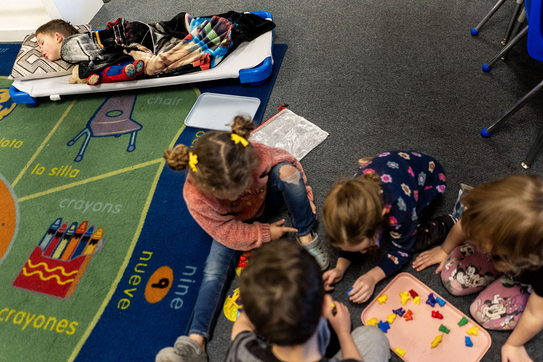A child sleeps as some of his classmates play during nap time at a daycare center in Nampa, Idaho.