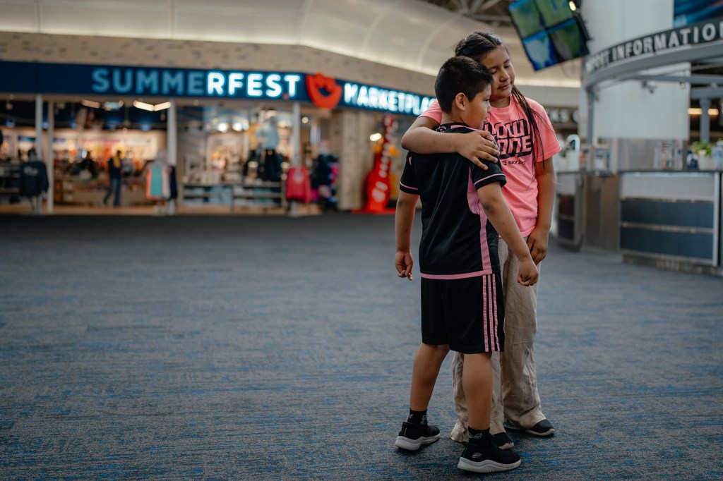 Elizabeth Guerra hugs family members at Milwaukee Mitchell International Airport before leaving for El Salvador.