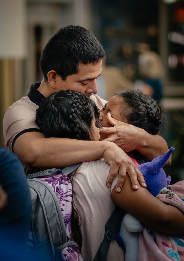 Miguel Guerra embraces his 10-year-old twin daughters before they leave with their mother as she self-deports back to El Salvador.
