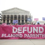 Anti-abortion protestors gather outside the Supreme Court holding a banner that reads 