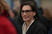 A woman smiles in a crowd.