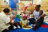 Two care providers hold infants in a daycare center.