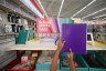 A child holds up a purple school notebook in a store.