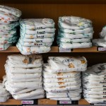Two rows of diapers stacked on shelves.