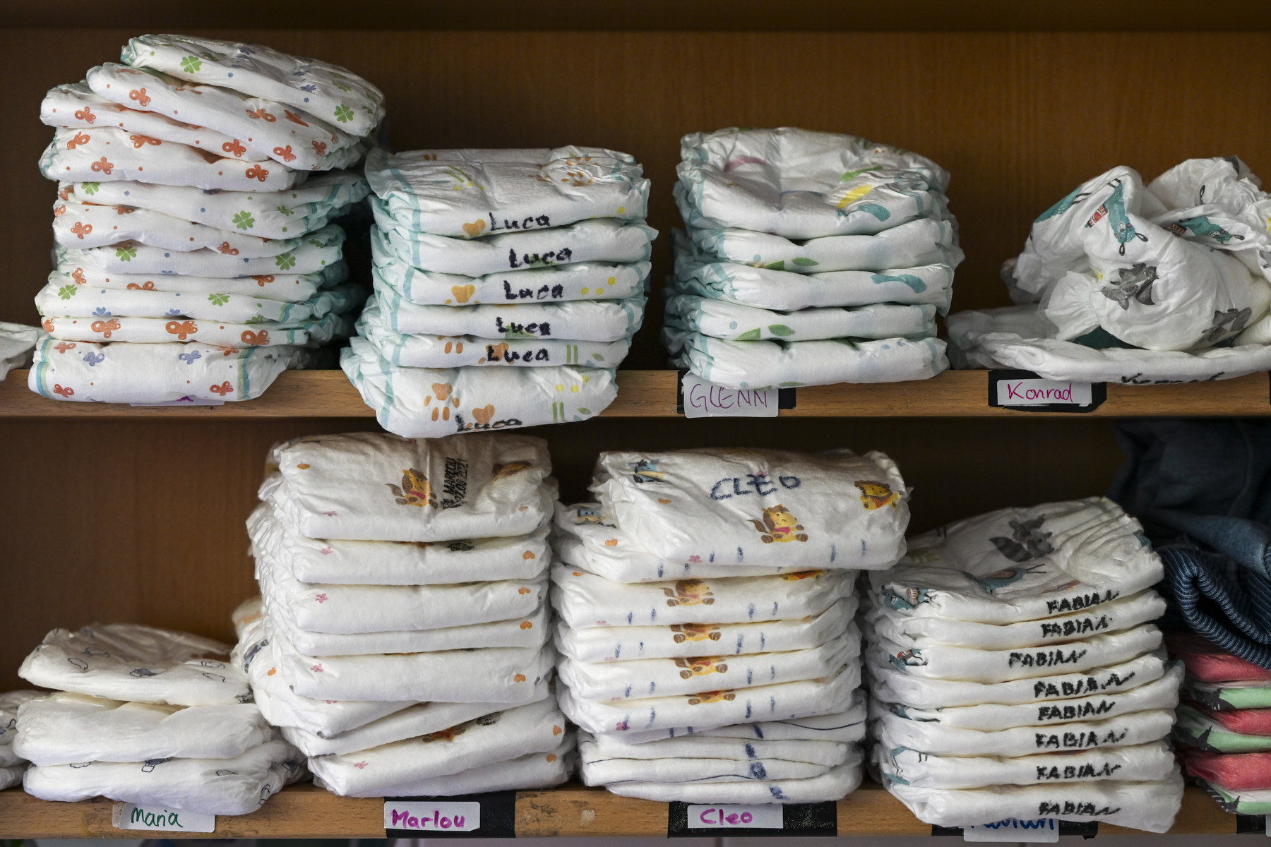 Two rows of diapers stacked on shelves.