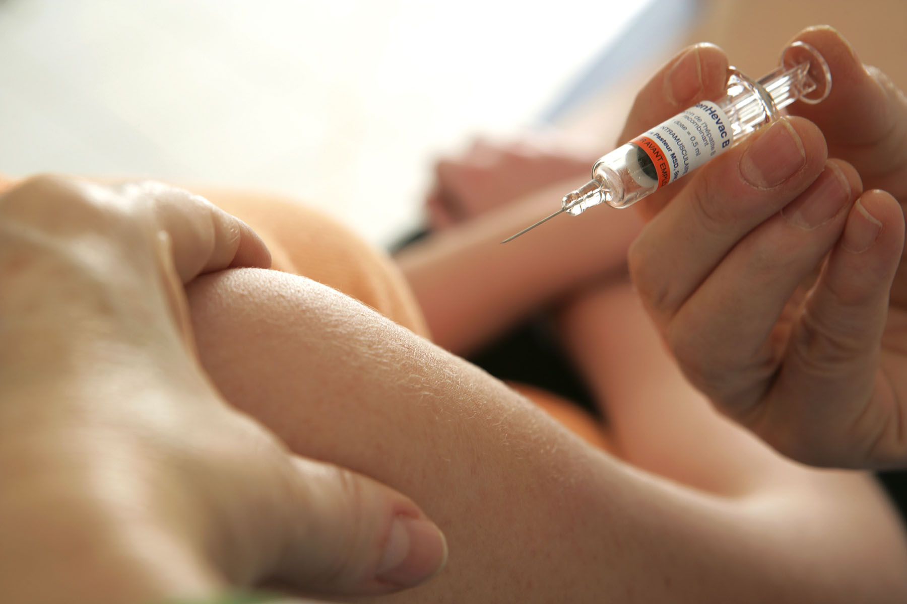 A person administers the vaccine against Hepatitis B.