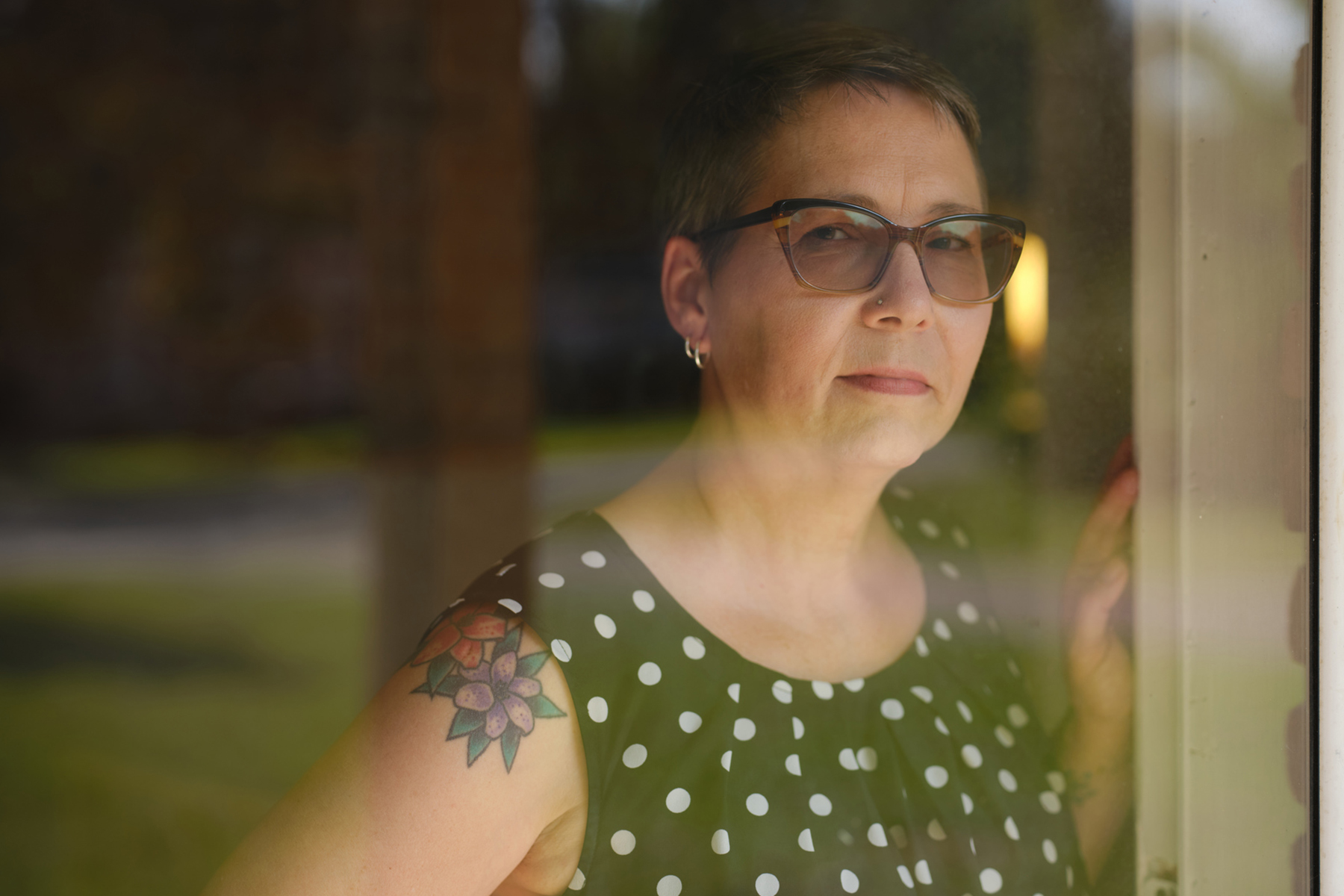 Portrait of Angela Thompson looking through a window