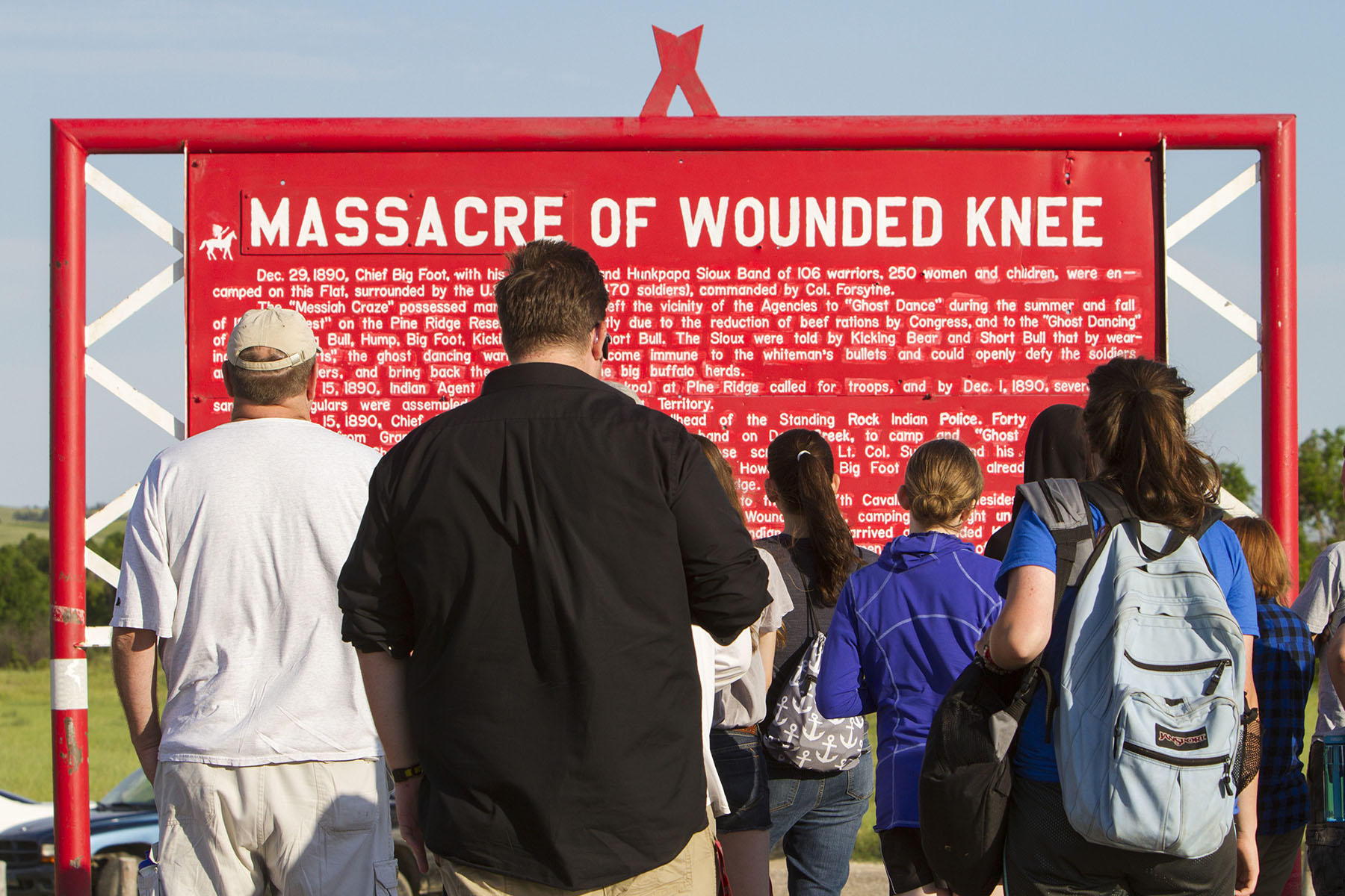People read a plaque at the memorial to the Wounded Knee Massacre that occurred on December 29, 1890, near Wounded Knee Creek on the Lakota Pine Ridge Indian Reservation.