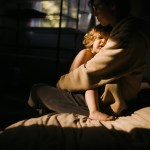 A sick child lays in their motherÕs arms.