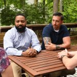 Rozia Henson speaks to constituents around a table in a backyard.