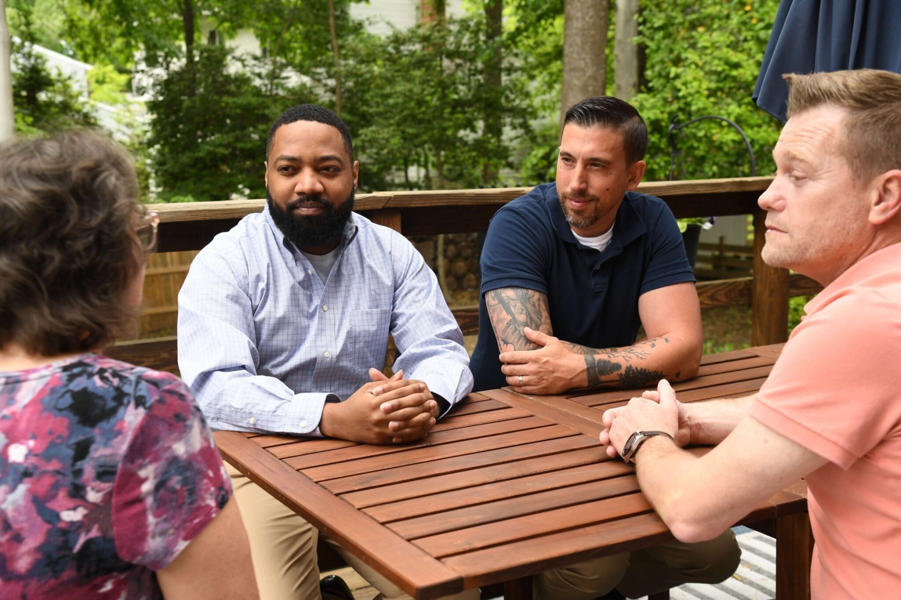 Rozia Henson speaks to constituents around a table in a backyard.