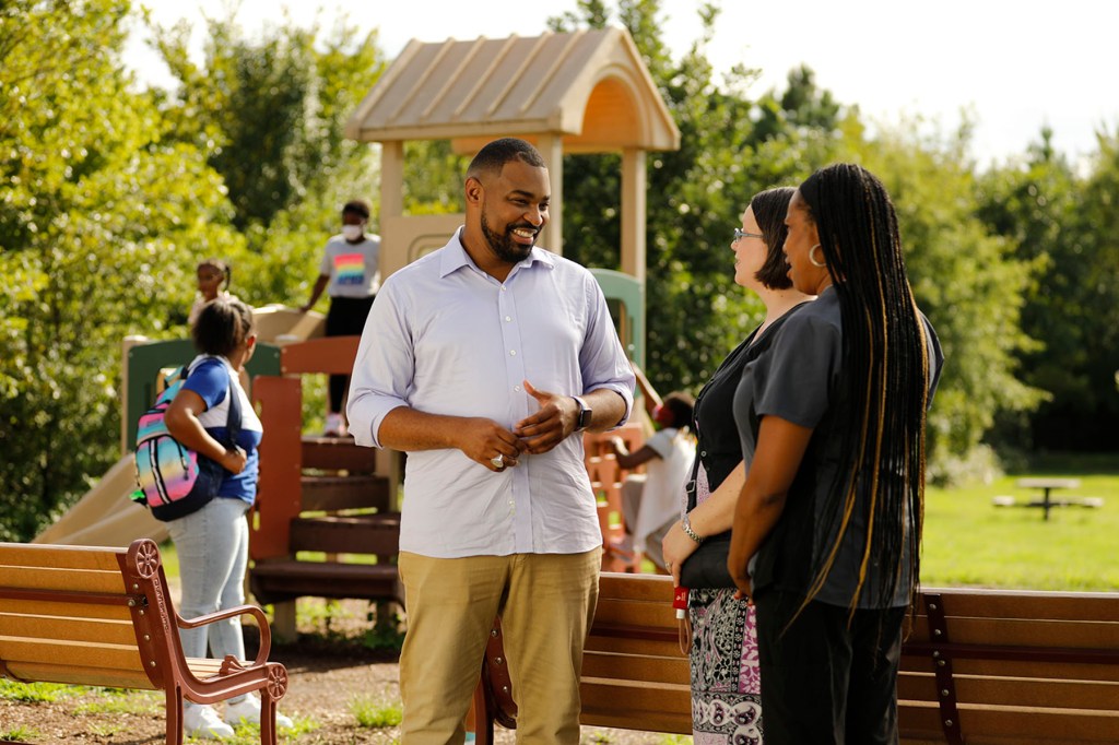 Del. Josh Cole speaks to constituents on a playground.