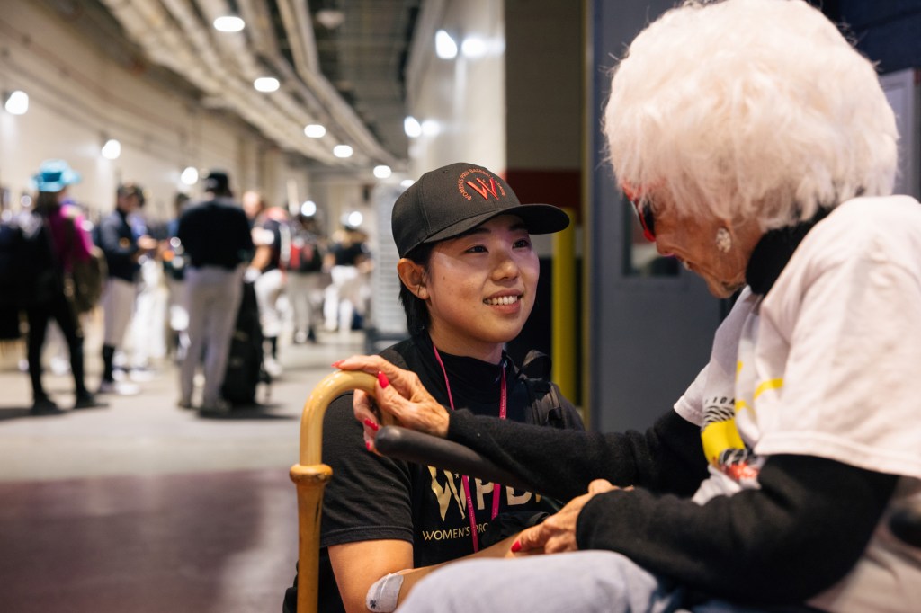 Kim Ra-kyung holds Maybelle Blair's hand as she leans down to chat with her in a hallway.holds Maybelle Blair's hand as she leans down to chat with her in a hallway.