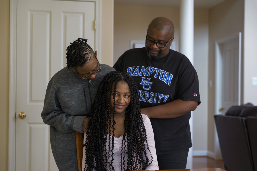 Milissa poses for a portrait with her parents, Keisha and Sean, at their home.