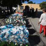 A woman walks by grocery carts full of food.