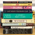 A closeup on a tower of banned books with other books in the background.