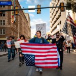 Young people march with upside down American flags at a protest in San Antonio, Texas.