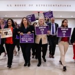 A group of people walk with signs saying 