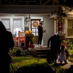Trick-or-treaters are seen leaving a house in costume.