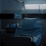 A dimly lit empty hospital bed.