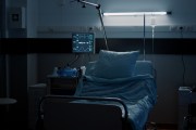 A dimly lit empty hospital bed.