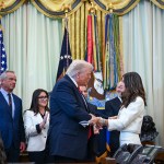 President Trump shakes hands with Samantha Busch during an announcement in the Oval Office of The White House.