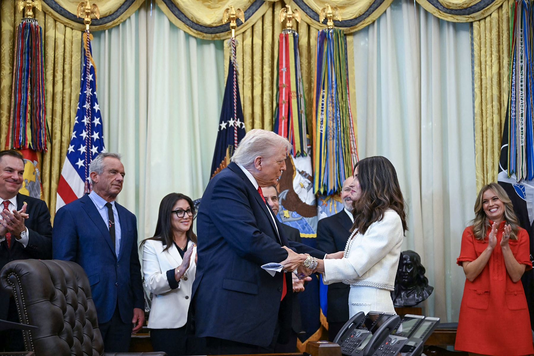 President Trump shakes hands with Samantha Busch during an announcement in the Oval Office of The White House.