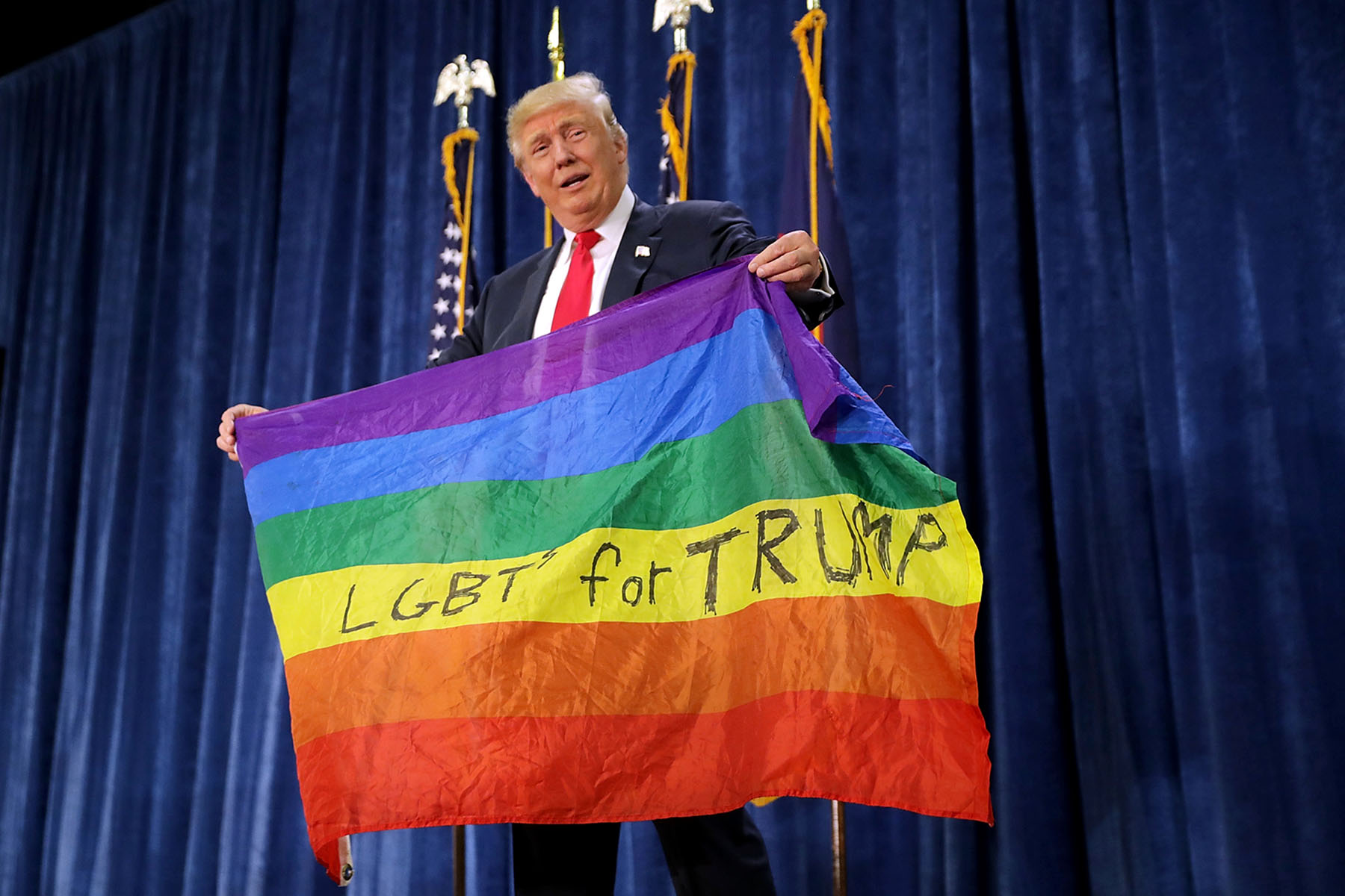 Donald Trump holds a Pride flag during a campaign rally in Greeley, Colorado.