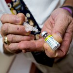 A doctor prepares a shot of the HPV vaccine for a patient at his office.