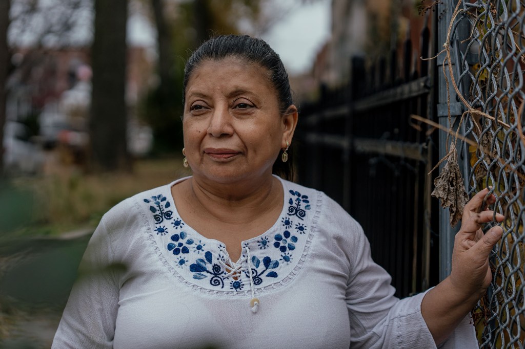 Claudia Pellecer, who runs a small daycare for young children out of her home, stands for a portrait outside her house.