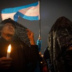 People wearing dark capes attend a vigil to commemorate Transgender Day of Remembrance in San Francisco.