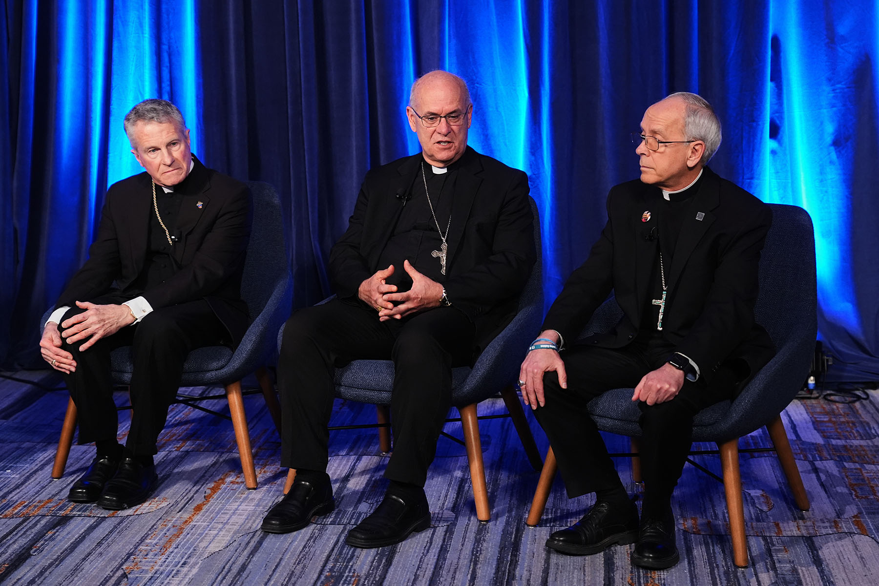 From left, Archbishop Timothy Broglio, Bishop Kevin C. Rhoades and Bishop Mark J. Seitz speak during a press conference at the United States Conference of Catholic Bishops plenary assembly.