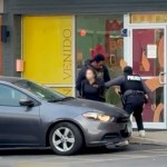 Two Immigration and Customs Enforcement officers detain a woman outside a day care in Chicago’s Roscoe Village neighborhood, pressing her against a car as another officer moves toward the building entrance.