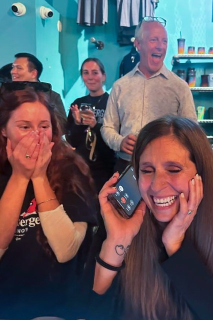 Jessica Anderson takes a phone call, surrounded by celebrating supporters.