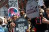People hold signs saying 