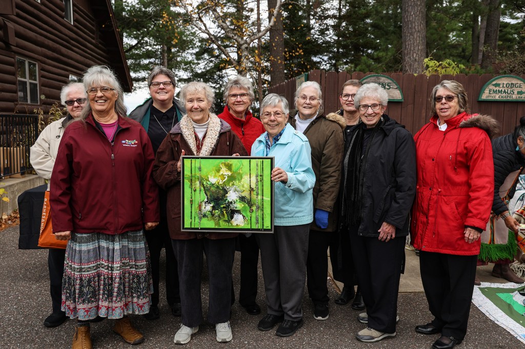 The Franciscan Sisters of Perpetual Adoration hold a painting they gifted the Lac Du Flambeau Band of Lake Superior Chippewa, a part of the Ojibwe Nation, as part of a ceremony on Friday that celebrated the historic land transfer.