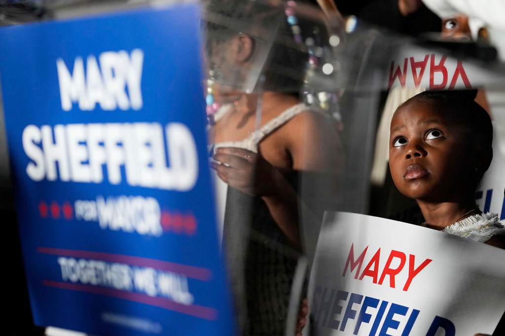 Tailynn Taylor, 4, stands on stage as Detroit mayoral candidate Mary Sheffield speaks at a campaign watch party.